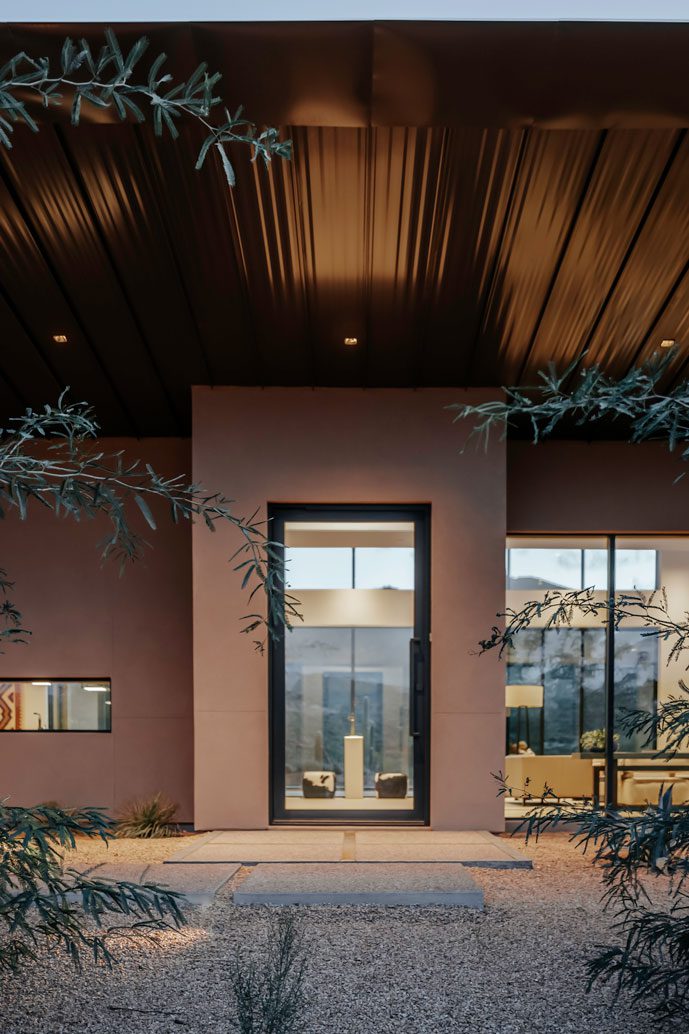 Front entrance of desert contemporary residence featuring floor-to-ceiling glass and minimalist materials