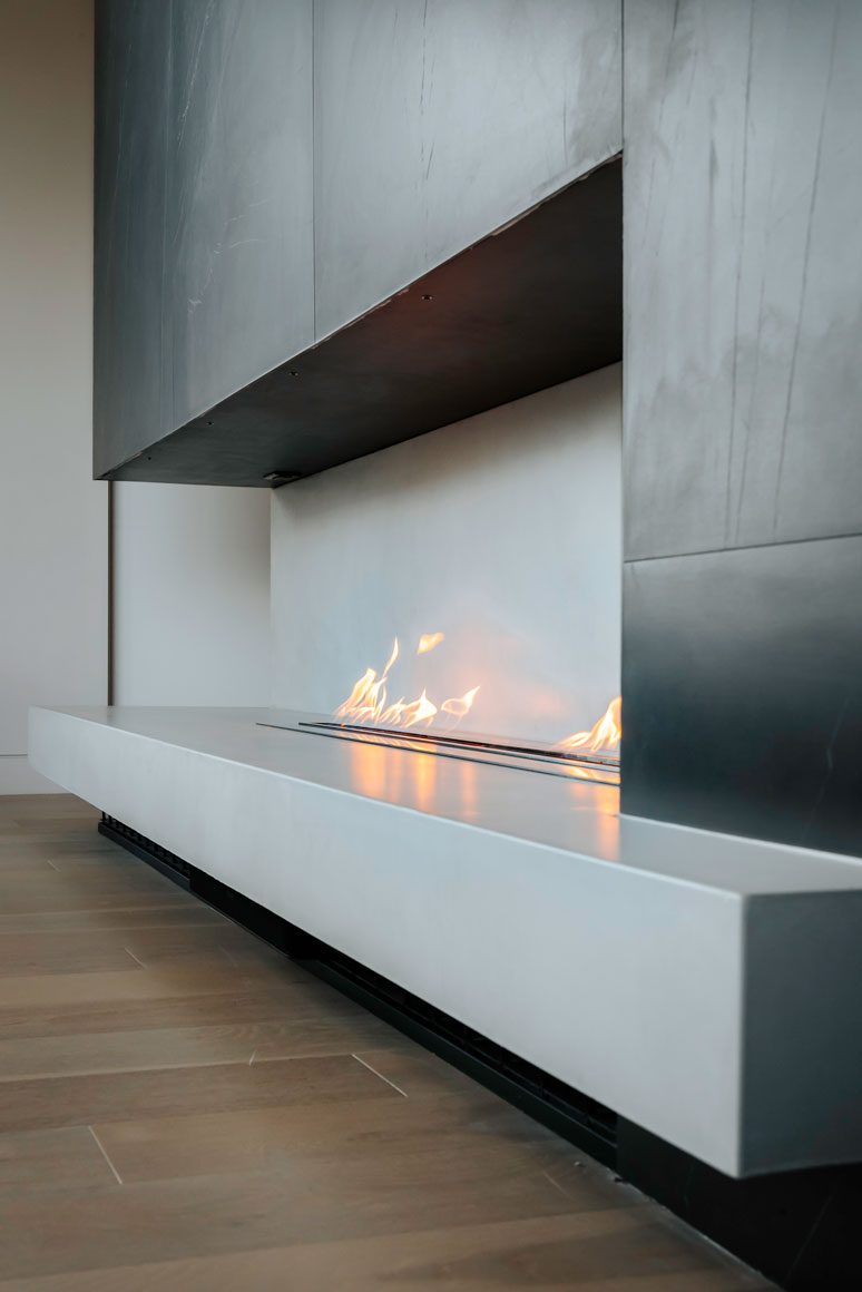 Contemporary fireplace detail with textured stone wall in modern desert living area