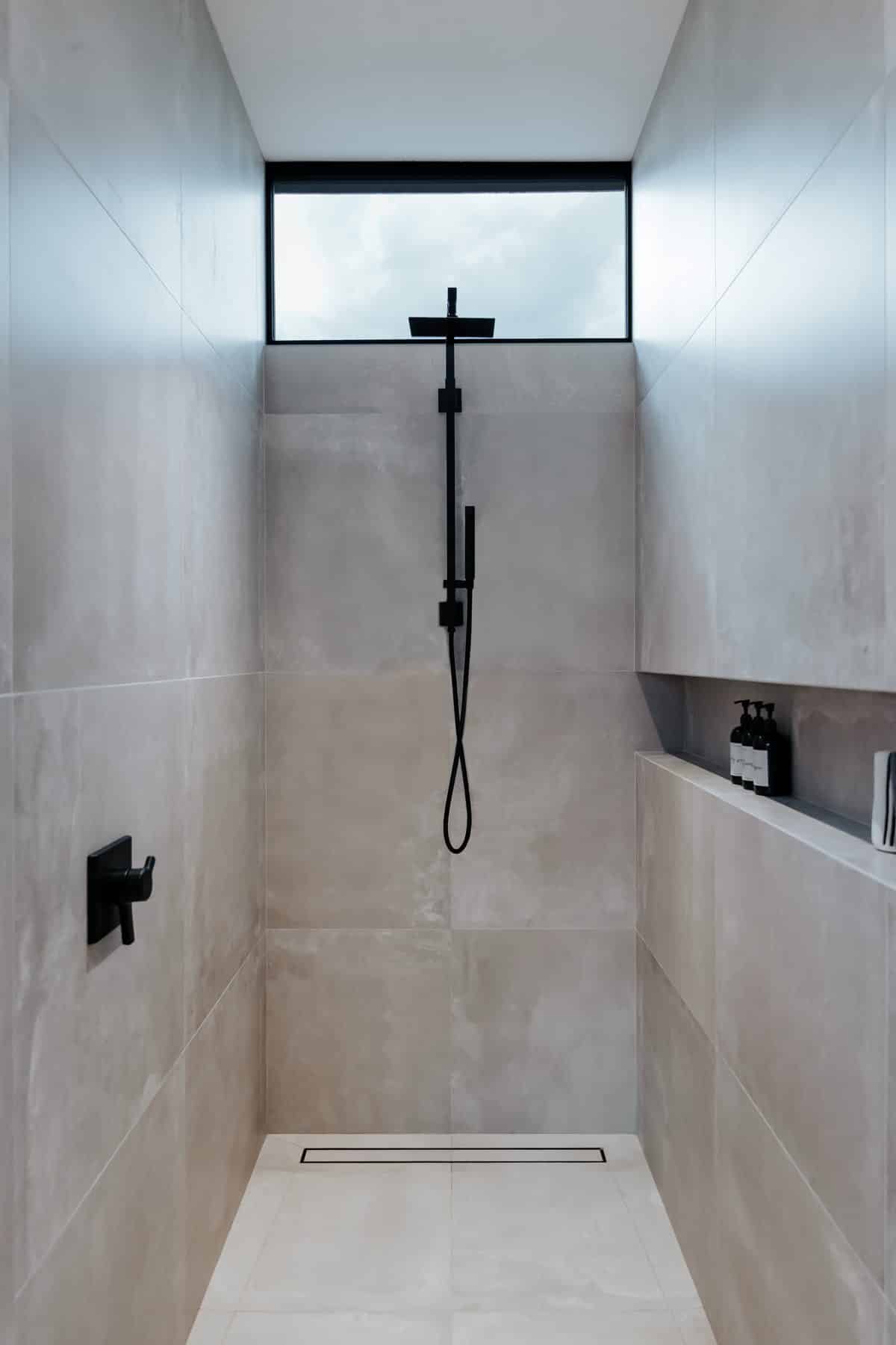 Walk-in modern shower with skylight and minimalist contemporary fixtures
