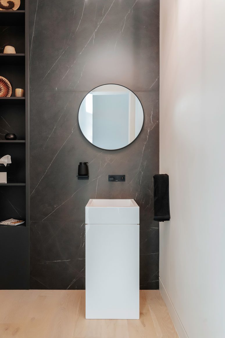 Custom powder bathroom with stone vanity and architectural accent lighting